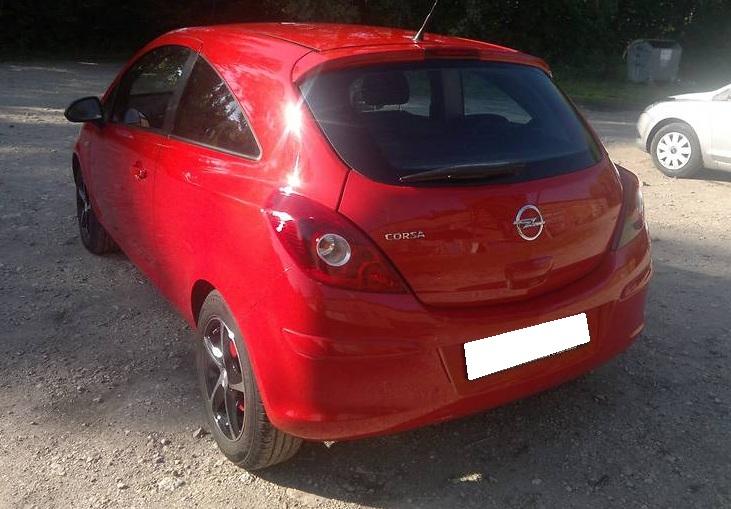 красный Опель Корса сзади