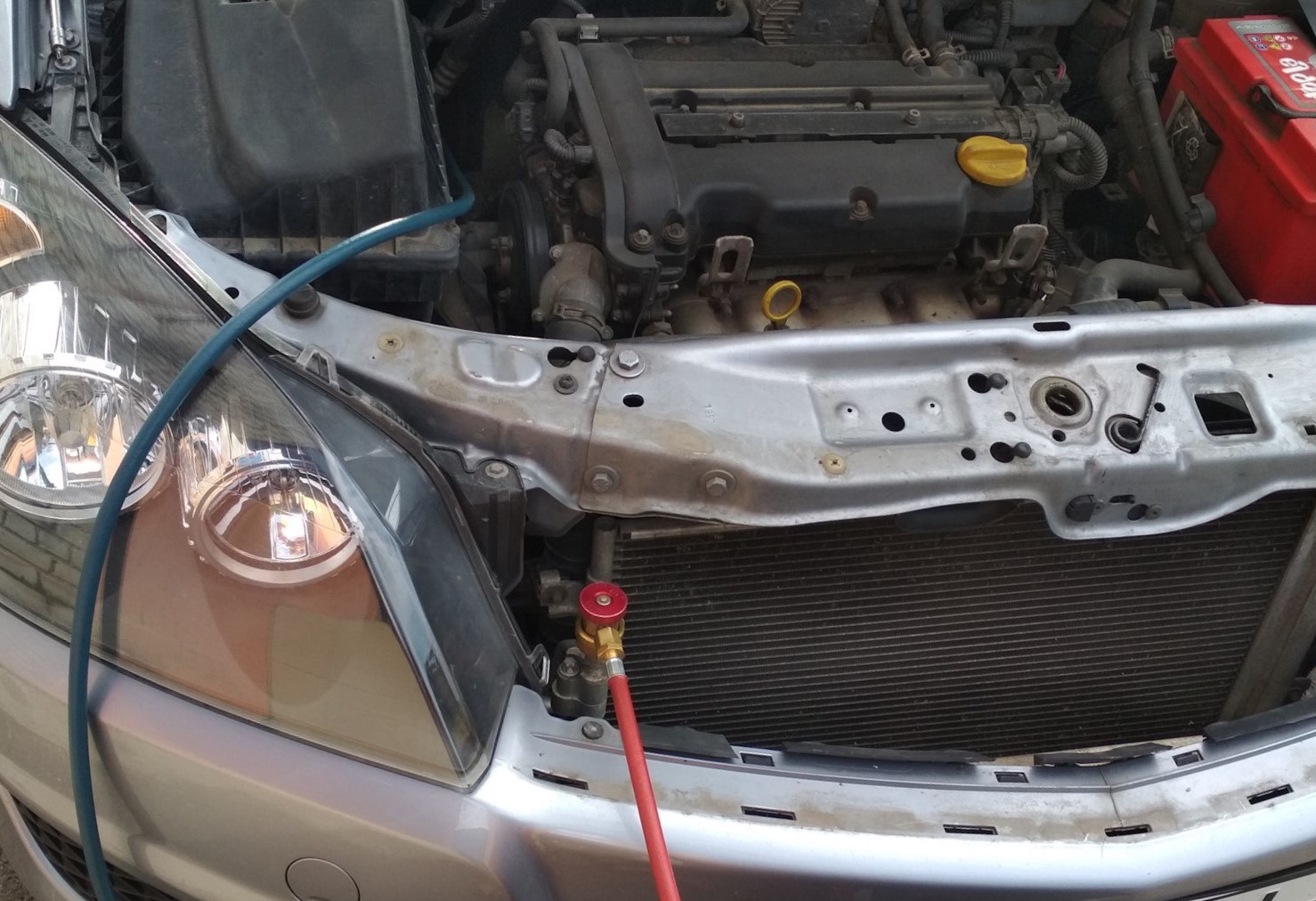 Опель Астра с подключенными шлангами для заправки кондиционера