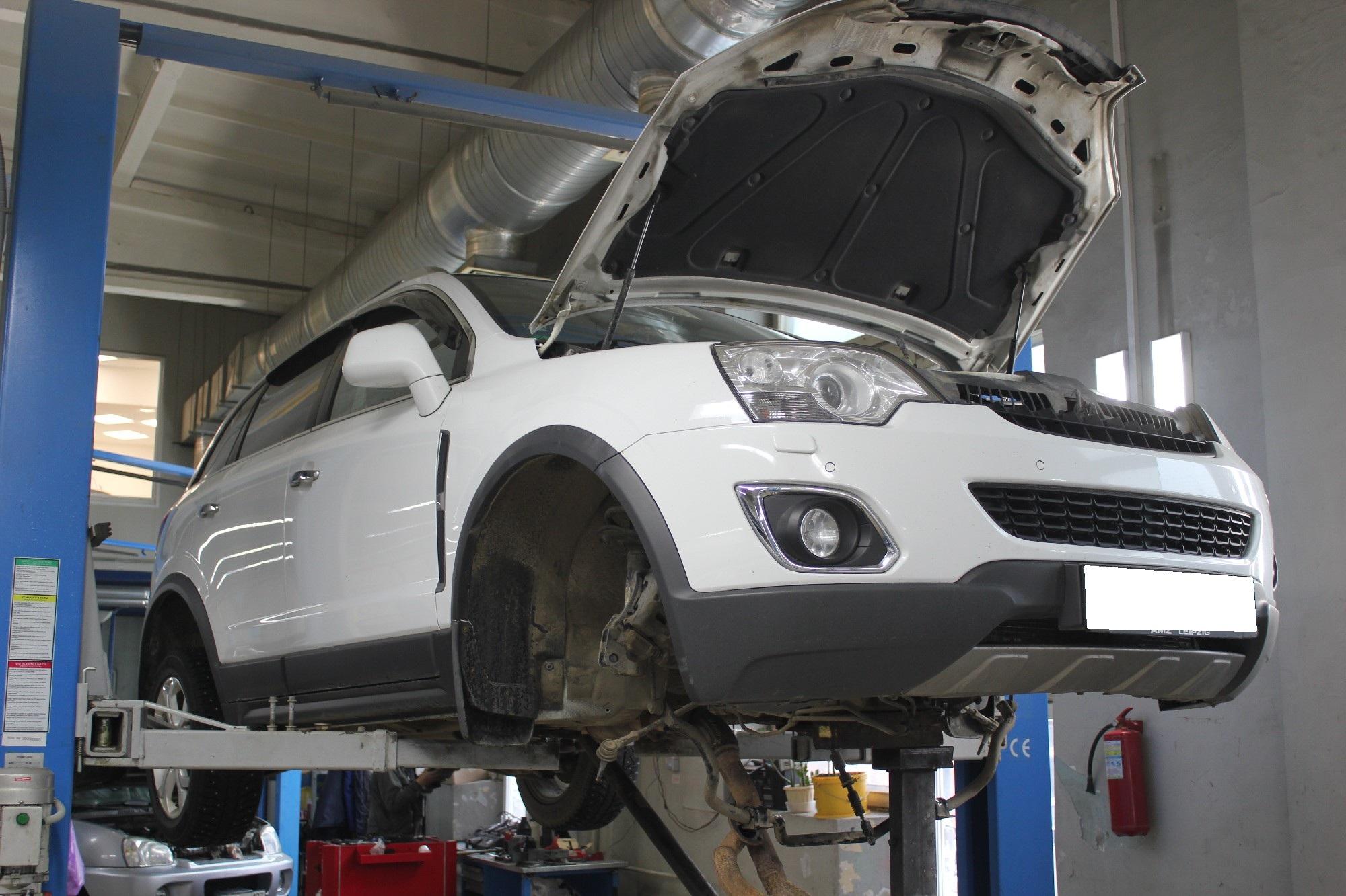 белый Опель на подъемнике в сервисе