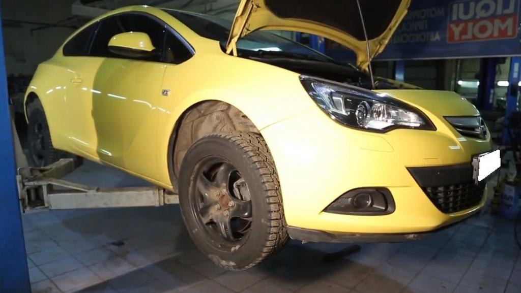 желтый Опель Астра GTC на подъемнике